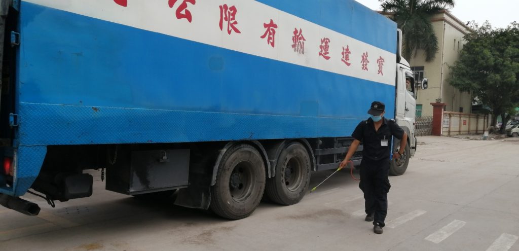 警備員さんが香港から材料を運んできたトラックを消毒している。
